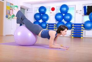 .feliz mujer joven haciendo ejercicio en un gimnasio foto