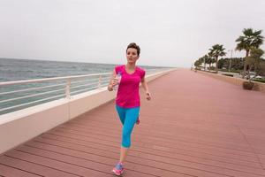 mujer ocupada corriendo en el paseo marítimo foto