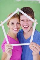 pareja feliz pintando una pared en su nuevo hogar foto