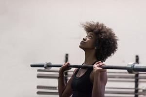 black woman lifting empty bar photo