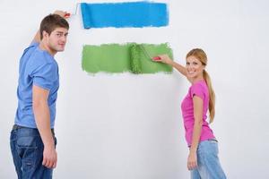 happy couple paint wall at new home photo