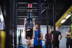 mujer trabajando con entrenador personal en anillos de gimnasia foto