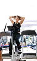 Women working out on spinning bikes at the gym photo