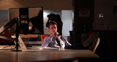 businessman sitting with legs on desk at office photo