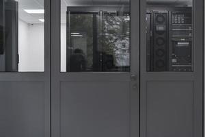 Software Engineer Working on a Laptop Computer in a Modern Server room. Monitoring Room Big Data Scientist in reflection of the entrance door. photo