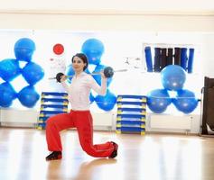 .una mujer joven levantando pesas en el gimnasio foto