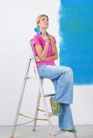 happy smiling woman painting interior of house photo