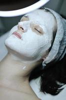 woman with facial mask in cosmetic studio photo