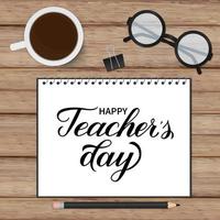 Happy Teachers Day calligraphy hand written in a notebook. Wooden texture background, glasses, cup of coffee and stationery. Vector template for typography poster, banner, flyer, greeting card, etc.