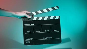 Crew hand holding plastic and wooden film slate board against camera. photo