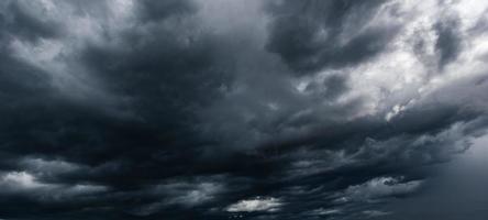 The dark sky with heavy clouds converging and a violent storm before the rain.Bad weather sky. photo