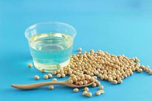 soybean and oil in a bowl on blue background, selective focus.copy space.front view. photo