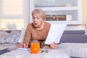 Senior woman doing finances at home. Senior woman with calculator and counting euro money at home. Business, savings, annuity insurance, age and people concept photo