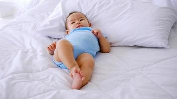 Adorable little baby lying on bed. photo