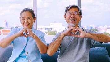 feliz pareja mayor que muestra el símbolo del corazón y la forma con las manos. foto