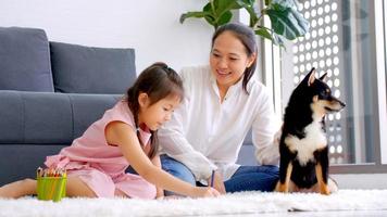 Mother and little daughter with their dog spending time together at home. photo