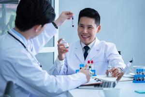 Scientist discussing with colleague about covid 19 vaccine in meeting room at hospital photo