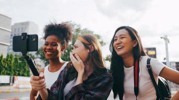 un grupo de amigas multiétnicas disfrutando del recorrido por la ciudad. jóvenes turistas divirtiéndose tomando fotos juntos.