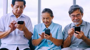 Group of senior friends using smart phone in a retirement home photo