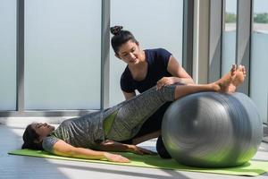 Two asian women doing yoga together at a gym. photo