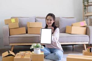 Portrait of Starting small Asian young businesses owners showing tablet with blank screen at home photo