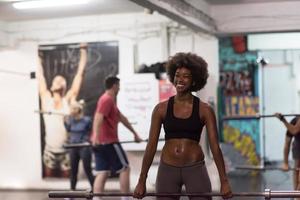 mujer negra levantando barra vacía foto