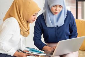 Two young muslim businesswomen discussing a work in the office. photo