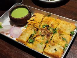 sabrosa comida india frita con relleno de pollo y chutney verde foto