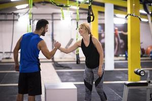 woman working out with personal trainer jumping on fit box photo