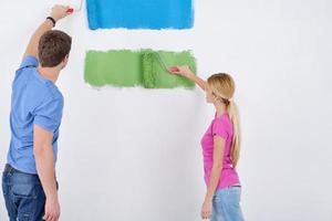 happy couple paint wall at new home photo