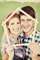 pareja feliz pintando una pared en su nuevo hogar foto