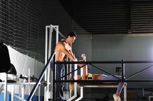 woman in the fitness gim working out with personal trainer photo