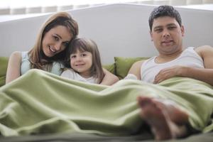 happy family relaxing in bed photo