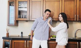 feliz pareja joven divertirse en la cocina moderna foto