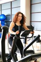 Women working out on spinning bikes at the gym photo