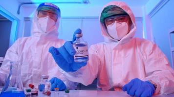 grupo de científicos en traje de ppe realiza investigaciones sobre la vacuna covid 19 en un laboratorio. foto