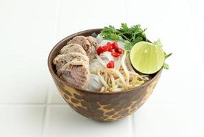 Tazón de sopa de fideos con carne pho vietnamita con vegetales foto