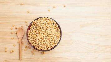 soybean in a bowl with wooden spoon on wooden background, top view, flat lay, top-down, selective focus.copy space. photo