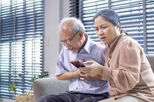 Asian senior man is suffering from heart attack while his wife is searching for paramedic doctor and ambulance rescue team for emergency situation concept photo