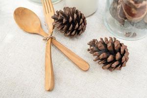 wooden spoon and wooden fork on the table covered with white cloth. photo