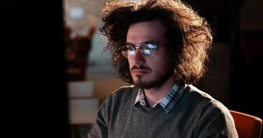 man working on computer in dark office photo