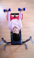 .una mujer joven levantando pesas en el gimnasio foto