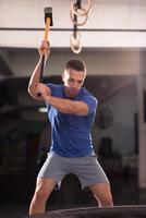 man workout with hammer and tractor tire photo