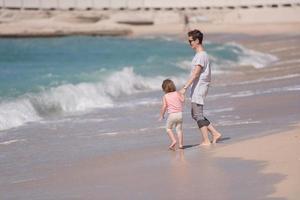 mother and daughter running on the beach photo