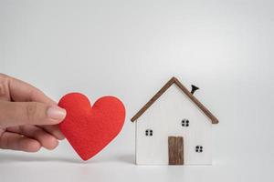 Giving heart to future house. Concept of protection or saving for buying new living area. Topic for loan and investment. photo
