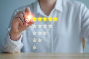 Customer Experience Concept. Review, increase rating or ranking, evaluation, feedback and classification concept. Businesswoman tick checkmark on checkbox for five yellow stars to rating review. photo