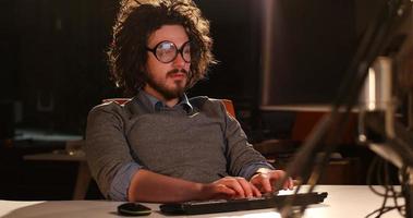 man working on computer in dark office photo