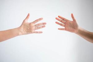 Two person playing rock paper scissors with both posturing paper symbol on white background. photo