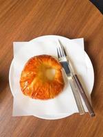 croissant recién hecho servido en una mesa redonda de madera en la cafetería. foto