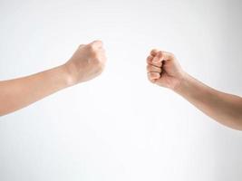 Two person playing rock paper scissors with both posturing rock or hammer symbol on white background. photo
